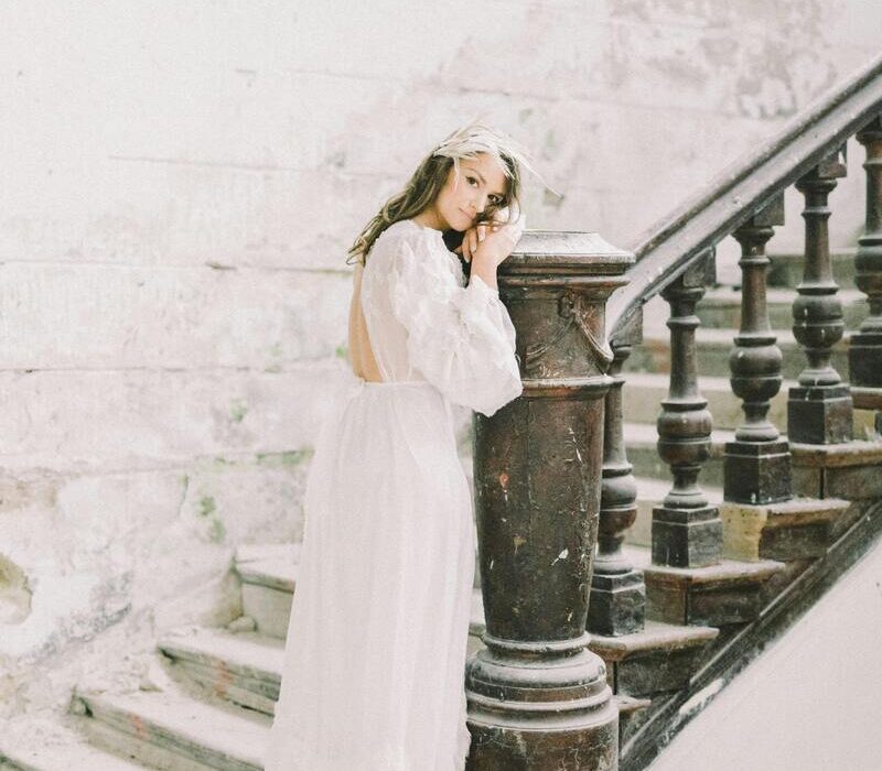 Une mariée en robe de mariée blanche dans un décor enneigé autour d'elle.